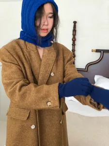 Detailed view of a cozy knitted balaclava hood and winter scarf in solid blue. Soft wool blend, warm style.