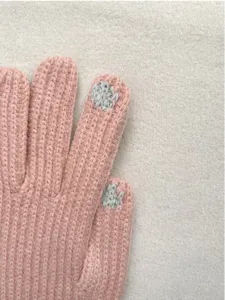 Nahaufnahme von rosafarbenen Winter-Strickhandschuhen mit leitfähigen Fingerspitzen.