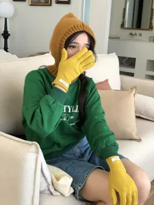 Detail view of winter warm wool gloves, solid yellow touchscreen design for women. Cozy stylish knit wear.