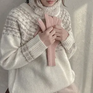 Nahaufnahme der warmen Winter-Touchscreen-Strickhandschuhe in Rosa, kombiniert mit Pullover.