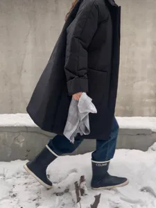 Detailansicht eines eleganten grauen Karoschals im winterlichen Schnee. Weiche Textur.
