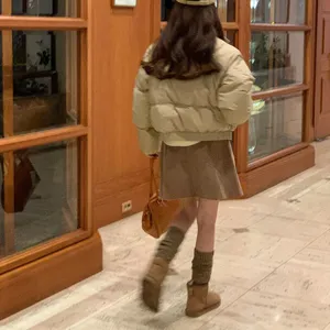 Effen bruine wollen beenwarmers gecombineerd met stijlvolle herfstlaarzen en een chique outfit.