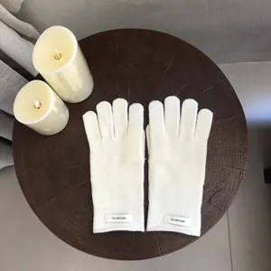 Detailed close-up view of cozy winter knit gloves in minimalist style on wooden table.