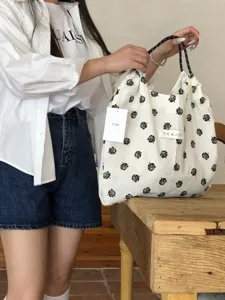 Detailaufnahme der koreanischen blumigen Kordelzug-Tragetasche mit schwarzem Rosenmuster.