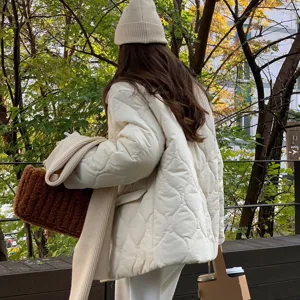Vue détaillée de la tenue d'hiver avec bonnet tricoté et veste matelassée en extérieur.
