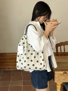 Detailansicht der stilvollen schwarz-weißen Kordelzug-Tasche mit Blumenmuster für Frühling.