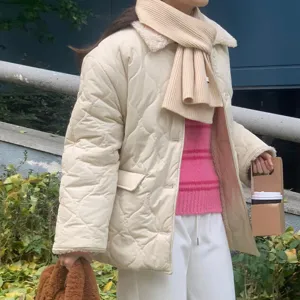 Détail d'écharpe tricotée d'hiver et de veste matelassée pour un look chaud et confortable.