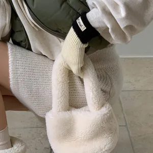 Detailweergave van warme gebreide handschoenen en pluizige tas, stijlvol winteraccessoire.