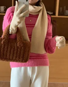 Vue détaillée d'un ensemble tricoté d'hiver chaud, pull rayé rose confortable et sac en peluche.