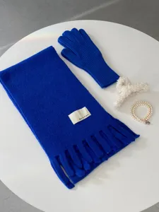 Detailansicht von blauem Strickschal und warmen Handschuhen mit schicken Accessoires.