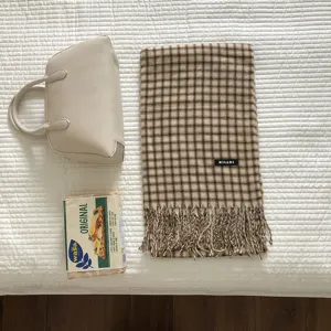 Winterlicher warmer Karoschal mit Fransen im Detail, elegantes Vintage-Muster, weicher Stoff.