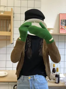 Primer plano de acogedores guantes de invierno de punto verde en una cocina elegante.