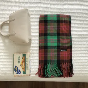 Detailansicht eines grünen Retro Karo Schals mit Fransen, warmes und stylisches Accessoire.
