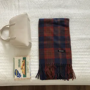 Nahaufnahme des klassischen rot-blauen Karo-Schals mit kuscheligen Fransen und Label.