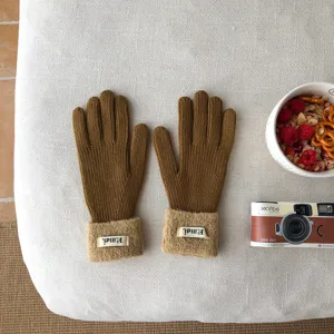 Braune gestrickte Touchscreen-Handschuhe mit flauschigen Bündchen, warme Wintermode.
