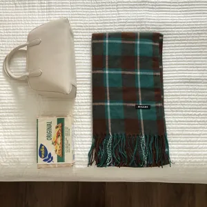Nahaufnahme Detail des vintage grünen Karomusterschals mit Fransen und Markenetikett.
