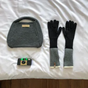Detailed view of grey knitted handbag and color-block long gloves set for winter warmth.