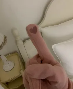 Κοντινό πλάνο σε ροζ βελούδινο γάντι παιχνιδιού με μοτίβο καρδιάς στην κρεβατοκάμαρα.