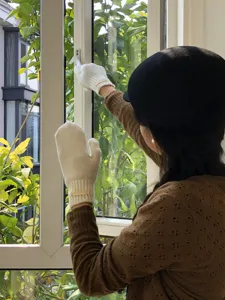 Vista detallada de mitones de lana blanca en la mano que muestran una textura tejida.