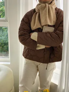 Gemütlicher Wollmisch-Winterschal perfekt kombiniert mit gesteppter Jacke im Detail.