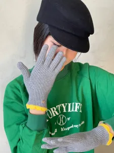 Detailaufnahme grauer Strick-Touchscreen-Handschuhe mit gelbem Wellenrand für den kalten Winter.