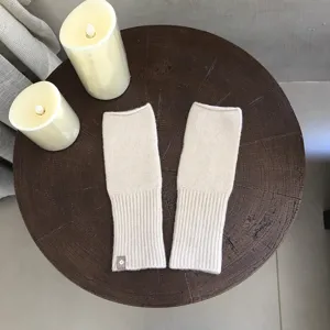 Detailaufnahme kuscheliger beiger fingerloser Strickhandschuhe, weiche Handstulpen für Alltag.