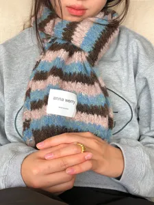 Dettaglio sciarpa invernale in mohair a righe multicolore, maglia morbida e accogliente donna.
