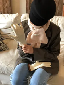 Detailansicht von warmen Strickhandschuhen und Schal, gemütliche Lifestyle-Szene.