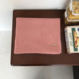 Detailansicht eines gemuetlichen rosa Strickschals aus Wolle mit feiner Rippenstruktur.