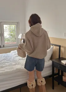 Cozy winter lifestyle scene featuring a plush fluffy handbag in a warm bedroom detail.