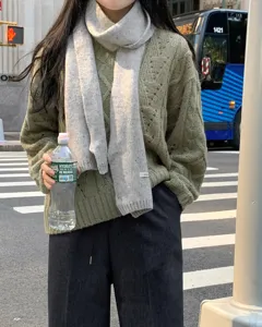 Winter warme gebreide wollen sjaal en kabeltruitje mode streetwear outfit voor dames.