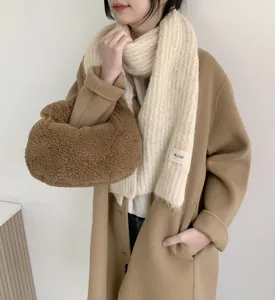 Detailansicht eines gemütlichen, cremefarbenen Mohair-Strickschals mit weicher Textur.