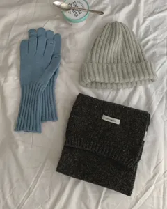 Gezellige winterbreisel set details met een wollen sjaal, muts en handschoenen.