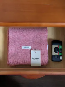 Gedetailleerd overzicht van een gezellige roze gebreide 100% wollen sjaal voor de winter.