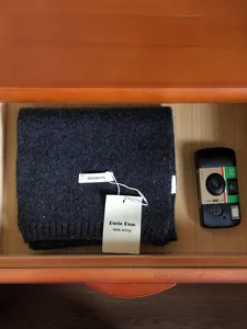 Gedetailleerd overzicht van donkergrijze wollen sjaal, gezellige gebreide textuur, warm accessoire.