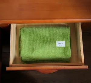 Grüner dicker Strickschal Detail, warmer Wollstoff für den Winter, gemütliches Accessoire.