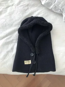 Black knitted balaclava detail view, cozy plush lining, functional buttons and drawstrings.
