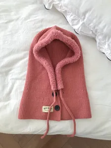 Pink knitted balaclava detail featuring cozy plush lining, functional buttons, and neat stitching.