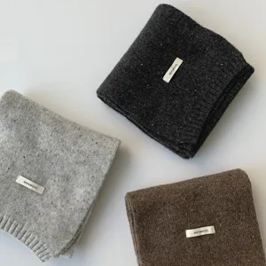 Minimalistische winter wollen sjaal met drie gekleurde gebreide sjaals netjes opgevouwen.