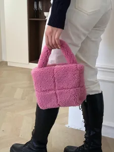 Detailed shot of trendy pink fluffy teddy fleece woven handbag featuring stylish padded grid texture.