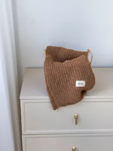 Detaillierte Nahaufnahme eines kuscheligen braunen Mohair-Strickschals mit weicher Textur.