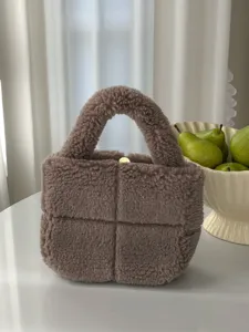Brown teddy fleece handbag with trendy padded grid design, cozy plush texture and top handle detail.