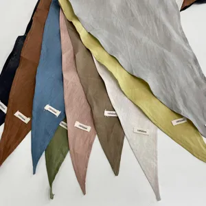 Vista dettagliata di foulard triangolari multicolore in lino puro disposti a ventaglio.