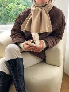 Detailaufnahme des kuscheligen khakifarbenen Strickschals, weich und warm für den Winter.
