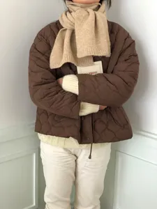 Gemütlicher Winterschal aus Wolle kombiniert mit Steppjacke und Pullover für kalte Tage.