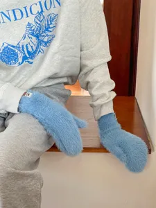 Nahaufnahme von flauschigen Winter Plueschhandschuhen in Hellblau, kuschelig und warm.