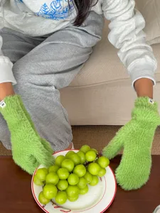 Nahaufnahme der flauschigen grüne Winterhandschuhe mit weicher Plüsch Textur und Etikett.