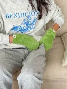 Gemütliche Winter Plüsch grüne Fäustlinge mit lässigem grauem Sweatshirt, sehr warm.