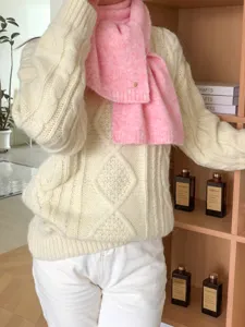 Gemütlicher rosa Winterschal kombiniert mit einem warmen Beigen Zopfmuster Pullover.