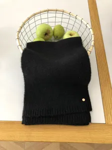 Gemütlicher schwarzer Winter-Strickschal Detailaufnahme, weiche warme Wollmischung Textur.